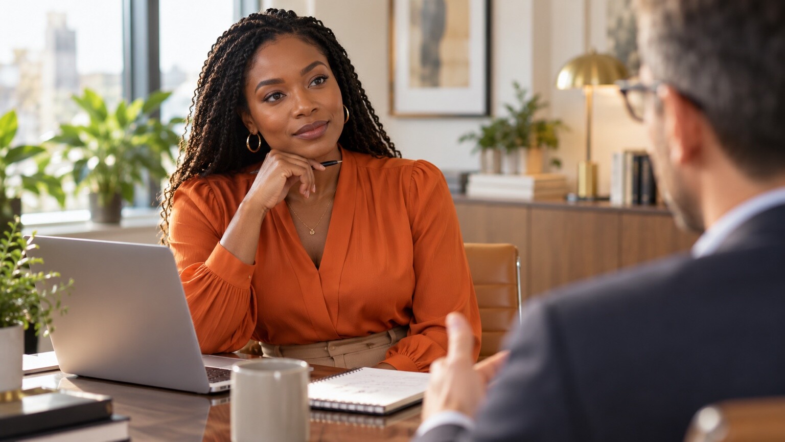 Professional woman listening calmly while receiving workplace feedback from a colleague.